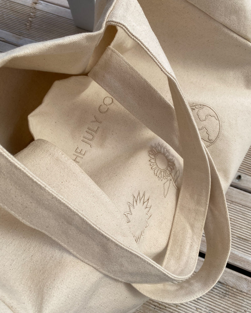 The Earth Tote Bag by The July Co made from 100% heavy weight Fairtrade organic cotton, with side panels for extra space and wide straps for durability. Three symbols embroidery design on front. Perfect beach bag or for travel and weekend breaks.