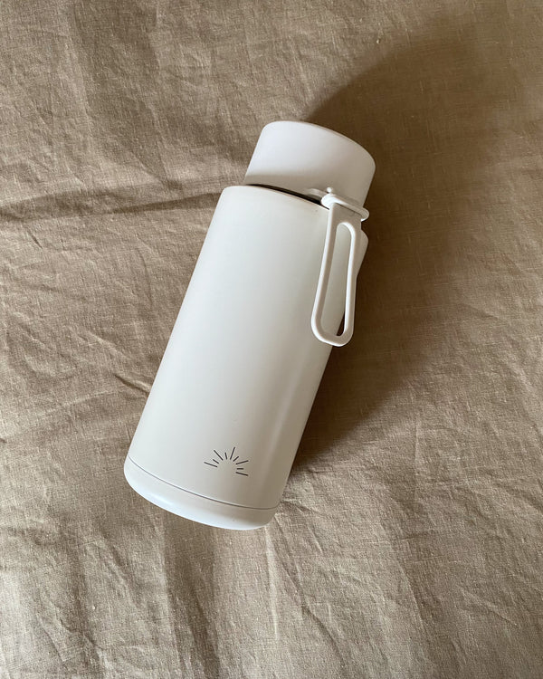 Our 1L ceramic reusable bottle by Frank Green with engraved sun logo in Cloud. Featuring a straw lid with a metal inner straw.